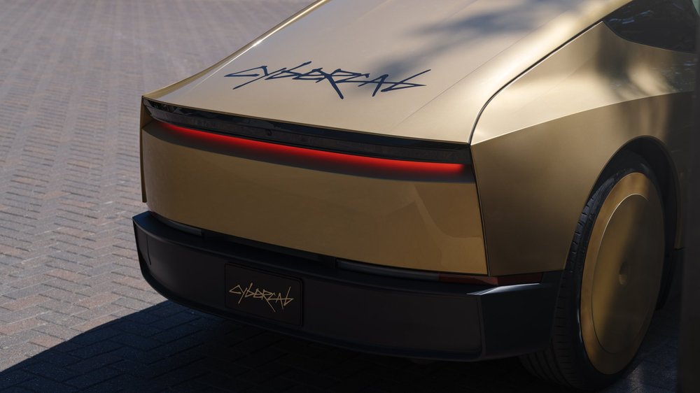 Rear of a gold Cybercab with CYBERCAB badge and red light bar